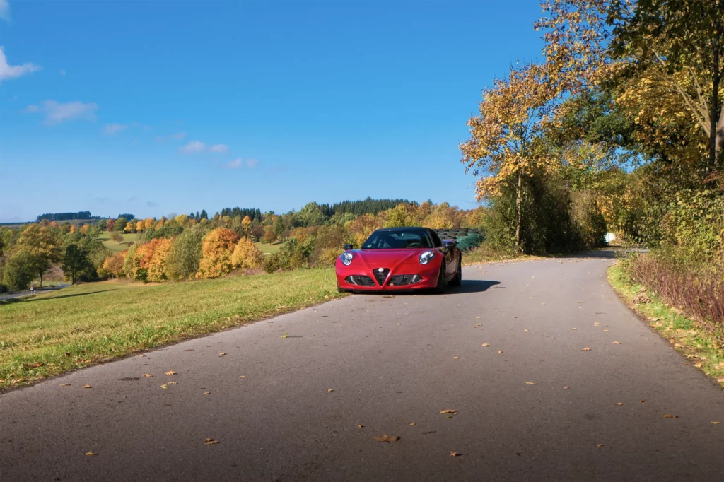 roter Alfa Romeo 4C vor herbstlicher Kulisse